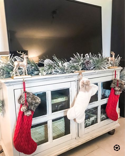 No mantle no problem!! 😍 your TV stand can work as your stocking holder for the holidays! 🙌🏼❤️ just cute some cute stocking holders (these sparkles reindeer are only $10!) and some garland (only $20!) ❄️📲 You can instantly shop all of my looks by following me on the @liketoknow.it app! http://liketk.it/2yxB3 #liketkit #LTKholidaystyle #LTKholidayathome #LTKeurope #LTKsalealert #LTKstyletip #LTKunder50 Tv Stand Stocking, Stocking Holders On Tv Stand, Stocking On Tv Stand, Christmas Stockings On Tv Stand, Tv Stand Garland Christmas, Tv Stand Christmas Garland, Garland On Tv Stand Christmas, Christmas Garland On Tv Stand, Stockings On Tv Stand