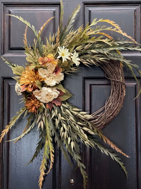 Bring the feeling of fall into your home with this wreath composed of mountain fern, oat seeds, peonies, hydrangeas, dahlias, and petite berries. This wreath features a mix of beige, brown, and green colors for a more realistic fall look. Add this piece to your front door or your wall for a look inspired by autumn this season.  [ Measurements ] Height: 25 in Width: 20 in Depth: 6 in Fall Wreath With Velvet Ribbon, Fall Decor Floral, Trending Wreaths 2024, Harvest Wreaths For Front Door, Fall Boho Wreath, Minimalist Fall Wreath, Modern Fall Wreaths For Front Door, Autumnal Wreaths, Fall Wreath Ideas Diy