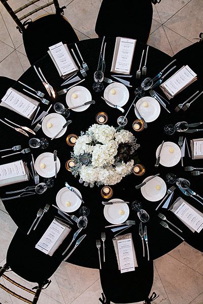 Think you can't use black as a primary wedding color? Think again. When paired with white, the effect is so timeless that you'll still love looking at your photos decades from now. Elegant Black Table Decor, Centerpieces For Black Tablecloth, Modern Romantic Wedding Reception, Black Tie Round Table Decor, Black Table Cloth Centerpiece, Black Tablecloth White Flowers, Wedding Tablescapes Black Tablecloth, Black Tablecloth Decor Wedding, Black Linen Table Setting