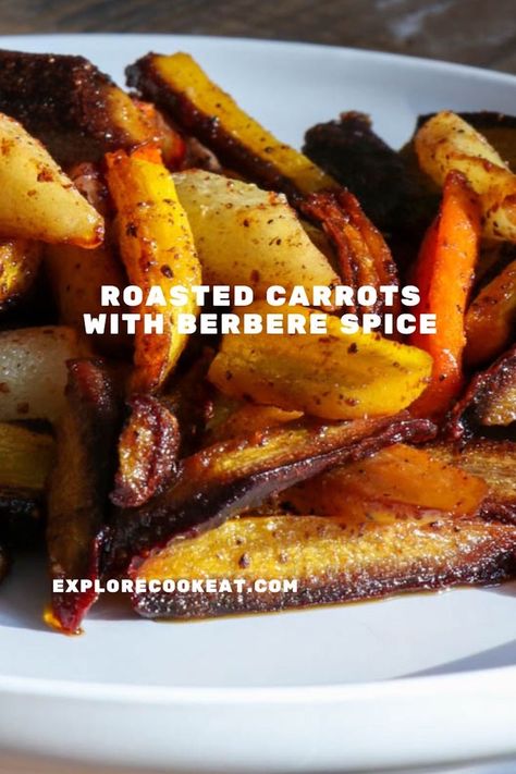 A white dish containing roasted carrots seasoned with Berbere spice.