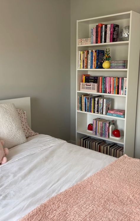 White book shelf filled with books and cute decor next to a bed with white bedding and a pink blanket on top. Bookshelf Inspo, White Bookshelf, Bookshelf Inspiration, Rustic Retreat, Room Deco, Cozy Room Decor, Dream Room Inspiration, Room Makeover Bedroom, Room Makeover Inspiration