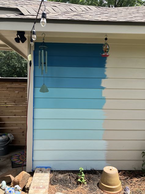 Hardie board garage wall in backyard painted ombré blue/aqua Painted Garage Walls Exterior, Garden Fence Mural, Painted Shed Mural, Backyard Wall Painting Ideas, Wall In Backyard, Garage Mural Ideas, Shed Murals Outdoor, Painted Fences Ideas Backyards, Shed Painting Ideas