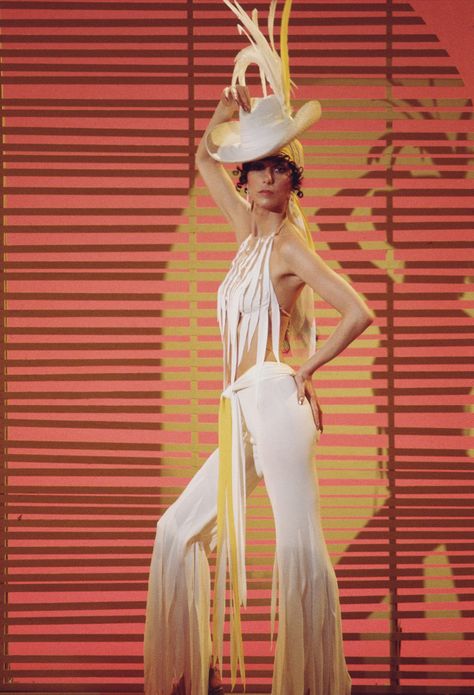 Cher sports a white halter-top, bell-bottoms, and feathered hat while promoting her CBS variety show “The Sonny & Cher Comedy Show” in 1972. Photo by CBS Photo Archive / Getty Images. Hippies, 1960s Fringe, Cher 70s, Cher Fashion, Cher Looks, Mode Disco, Cher Show, The Cher Show, Cher And Sonny