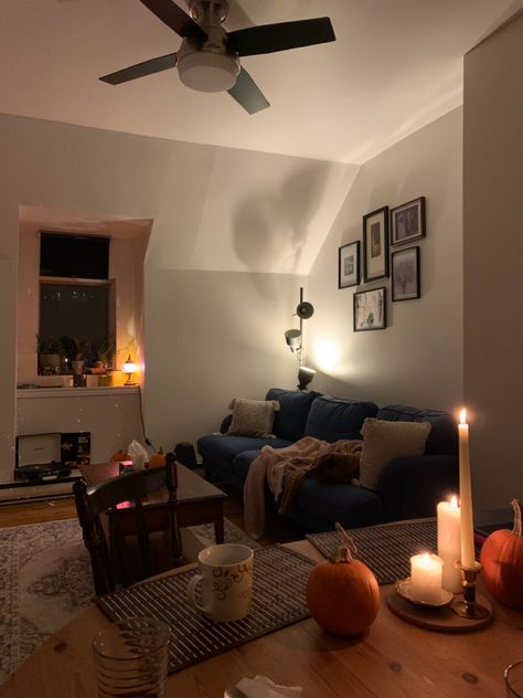 Candles, blue couch, pumpkins, decor, home, cozy living room aesthetic Navy Couch Aesthetic, Dark Blue Apartment Decor, Dark Blue Living Room Aesthetic, Apartment Living Room Blue Couch, Navy Blue Couch Aesthetic, Blue Living Room Apartment, Blue Couch Decor Ideas, Living Room With Dark Blue Couch, Blue Couch Aesthetic