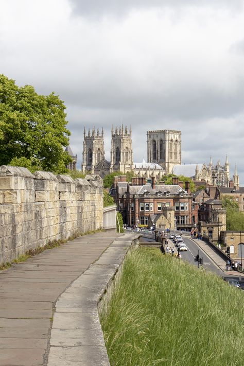 The York City Walls is the longest medieval town walls in England and also the best preserved. They can be accessed through four main and two secondary gates. But before we dwell on these, let me tell you all about the amazing history of the York City Walls. Walking along the York Bar Walls the whole trail takes approximately two and a half hours and offers fantastic views of the city. Click on the link to find out more about The York City Walls! #york #england #architecture #history #travel York City Walls, York City Walls England, University Of York England, York City England, York England Aesthetic, Whatpad Stories, 90s Wardrobe, Dr Images, North England