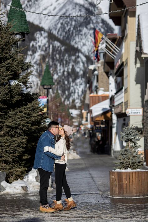 Banff Winter Engagement at Lake Minnewanka - Banff Engagement Photographer  via Kim Payant Photography, Cozy Winter Engagement Session Ideas - Banff  Engagement Photographer, Engagement Poses ideas, Where to take engagement photos, winter mountain Engagement, Downtown Banff Winter Engagement Session - Mountain Village Photo Session  #banffwinterengagement #banffengagementphotographer #cozyengagementphotos Engagement Poses Ideas, Street Engagement Photos, Banff Engagement, Banff Winter, Banff Elopement, Rocky Mountain Elopement, Village Photo, Engagement Session Ideas, Photos Winter