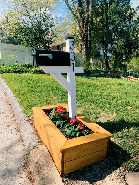 DIY modern white painted wood mailbox with stained flower bed. Mailbox Flower Pot Ideas, Mailbox With Flower Planter, Flower Beds In Front Of Double Wide, Wood Post Mailbox Ideas, Mailbox In Planter, Mailbox Flower Planter, Diy Wood Mailbox Ideas, White Mailbox Ideas, Diy Mailbox Ideas Outdoor