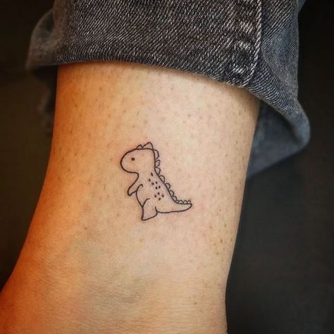 Small T Rex Outline Tattoo, Tattoo Ideas Female Dinosaur, Cartoon T Rex Tattoo, Dino Flower Tattoo, Velociraptor Tattoo Cute, Dinosaur Egg Tattoo, Dino Stick And Poke, Small Trex Dinosaur Tattoo, Rainbow Dinosaur Tattoo