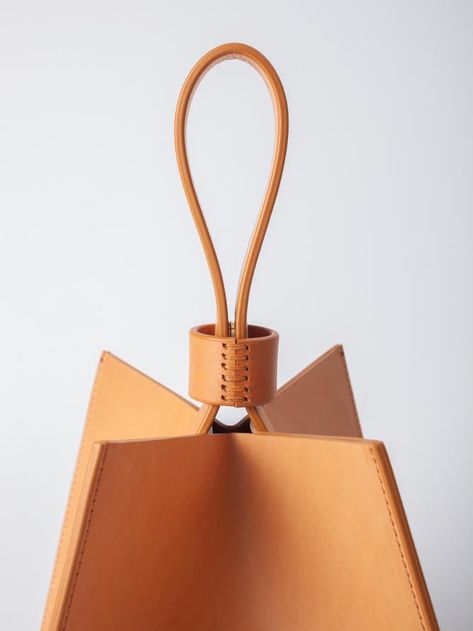 The Cube handbag is a pleasure to carry in your hand or on your wrist. The structural, unique cube shape offers spacious storage and boasts a hidden magnetic closure embedded in its handle. The 100% Veg-tanned Vachetta leather bag is intentionally unlined. Crafted with skill by artisans in the Arrhe Studios workshop in Fano, Italy. FIT & SIZING Dimensions: 8" x 8" x 8" DETAILS Fabric | 100% Veg Tanned Vachetta Italian LeatherColor | NATURALDesigner | ARRHE STUDIOS CARE The leather chosen is subj Luxury Bags With Leather Handles For Gifts, Studio Bag, Cube Shape, Unique Handbags, Colorful Handbags, Colorful Bags, Bag Clips, Original Fashion, Unique Bags