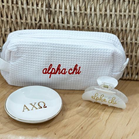 Select your assortment of Alpha Chi Omega gifts to make your own gift set! We'll package in a cellophane bag tied with ribbon in the sorority colors! Choose any combination of the these popular items, including the super trendy waffle weave bag, ring/pin dish with gold trim and the fun sorority embellished hair clip.  BAG: * 7.75" x 3.5" x 2.5" OR 7" x 4.75" x 3.5" * Poly/cotton waffle weave fabric exterior * Vinyl lined interior and one interior pocket RING/PIN DISH: This ceramic dish is 4" x 4" white ceramic porcelain with gold Greek letters. HAIR CLIP: 3-1/4" wide x 2.5" tall with heavy-duty claw design Personalized in high-quality printed vinyl on ONE side of the clip. ~ OTHER INFORMATION ~ Normal turnaround varies by item and is indicated in the shipping information. See shop announce Alpha Phi Baskets, Sorority Gift Ideas, Sorority Gift Baskets, Little Baskets Sorority Ideas, Sorority Big Little Baskets, Sorority Little Gifts, Axo Merch, Alpha Chi Omega Canvas, Adpi Recruitment