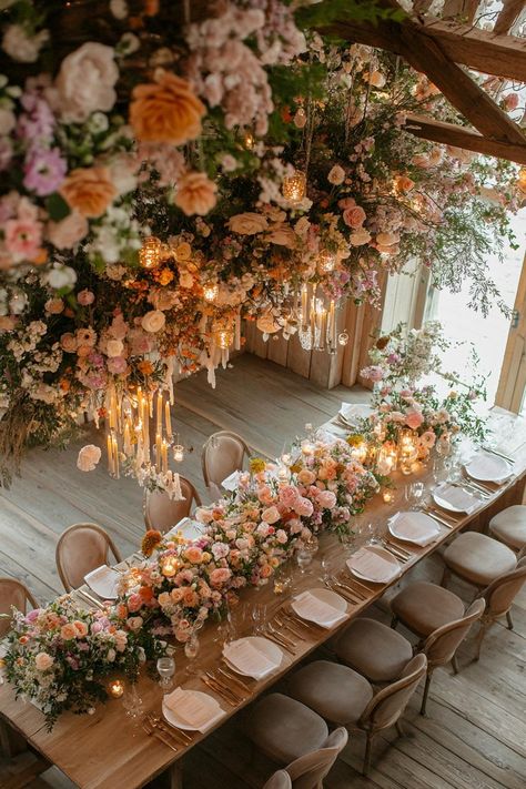 Elegant wedding table with lush floral arrangements and chandeliers. Unleash your inner florist with wild and whimsical floral wedding ideas that will make your special day bloom like never before. Elegant And Whimsical Wedding, Intimate Elegant Wedding, Dreamy Wedding Decoration, Moody Garden Party Wedding, Whimsical Theme Wedding, Bold Wedding Florals, Spring Florals Wedding, Floral Wedding Table Decor, Wedding Theme Ideas Elegant