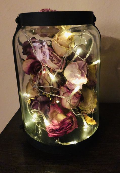 Wondering what to do with your dried roses? Take a string of mini lights, a decorative glass jar and arrange all together for a beautiful decoration that is also meaningful 💕 Dried Flower Petals In A Jar, Dried Roses Room Decor, Diy With Dried Roses, Dry Roses Decoration, Dried Roses Crafts, Rose Petals Decoration Ideas, Things To Do With Flowers From Boyfriend, Dried Roses Wedding Decor, Dried Rose Decoration