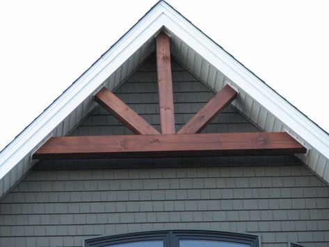 Accent beams through vinyl soffit Roof Peak Accents Wood, Peak Of House Exterior Decor, Gable Truss Exterior, Base Of House Ideas, Gable Peak Accent, Rustic Gable Front Porch, Wood Accent Roof Peak, Garage Peak Ideas, Wood Features On House Exterior