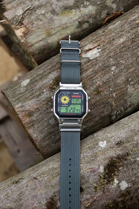 "Casio Custom Hydro Mod Royale AE1200 \"Urban Cruiser 22mm\" Watch Red, Yellow and Green Screen - Nylon Strap Digital Casio AE-1200W Vintage This is a custom watch Casio AE-1200 (Royale) that has a tri-tone red, yellow and green screen and a new 22mm nylon durable gray strap to complement desert colors and feel.  Strap is changed on this model of Royale, previous had 18mm strap on original lugs, but we have fitted 18 to 22mm silver colored adapters in order to conserve a beautiful 22mm form of the watch case endings. OPTIONAL: This one can also be oil-filled (hydromod) to increase contrast and water resistance to 200m worth of pressure. Great for outdoor activities. Stopwatch, alarm and 31 world zones. It's a digital watch that can be unique holiday gift. All our watches can be made as a p Casio Ae1200 Mod, Casio Ae1200, Casio Royale, Vintage Casio Watch, Vintage Digital Watch, Casio Vintage Watch, Casio Digital, Super Cool Stuff, Outdoor Watch