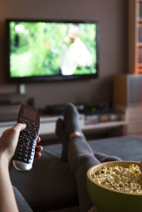 Woman relaxing at home watching tv and eating popcorn and surfing internet Someone Watching Tv, Watching Films Aesthetic, Tv Aesthetic Watching, Watching Tv Photography, Person Watching Tv, Watch Tv Aesthetic, Movie Watching Aesthetic, Watching Tv Video, Watching Tv Aesthetic