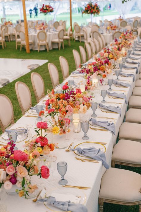 |NK Wedding Planning. Get in touch with us today.| Bay Preserve Wedding, outside wedding, tented wedding, floral centerpieces, pink, blue, orange, roses, gold, blue napkins, gold silverware, louis chair natural, ~Taken by Hunter Ryan Photo~ Vogue Wedding Tablescape, Wedding Lots Of Flowers, Pink And Orange Wedding Palette, Bright Summer Wedding Table Decor, Red Orange Pink Blue Wedding, Multi Color Flower Wedding, Love In Full Bloom Wedding, June Beach Wedding Colors, Colorful Wedding Linens