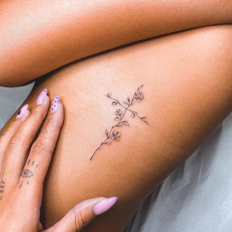 Fine line flower cross tattoo on the rib. Flower Cross Rib Tattoo, Tattoo Ideas Cross Flowers, Cross With Lilies Tattoo, Cross Flower Tattoo For Women, Feminine Biblical Tattoos, Small Cross With Flowers Tattoo, Beautiful Cross Tattoos, Tattoos For Faith, Woman Cross Tattoo