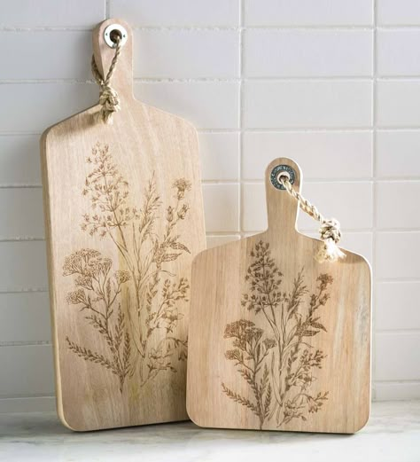 Handcrafted in Thailand, these nature-inspired Wildflower Etched Serving Boards made from natural mango wood are delicately etched with a wildflower design that graces these chic yet rustic boards. Pretty enough to hang on a wall yet perfectly sized to showcase a delightful cheese and charcuterie spread. Arrives with an attached jute cord for easy hanging. V4915,Wildflower Etched Serving Boards,Rectangle,serving board,wildflower,rustic,mango wood,handcrafted,chic Etching Wood, Ginkgo Design, Charcuterie Spread, Wildflower Design, Flora Design, Woodburning Projects, Laser Engraved Ideas, Wood Burning Crafts, Engraving Art