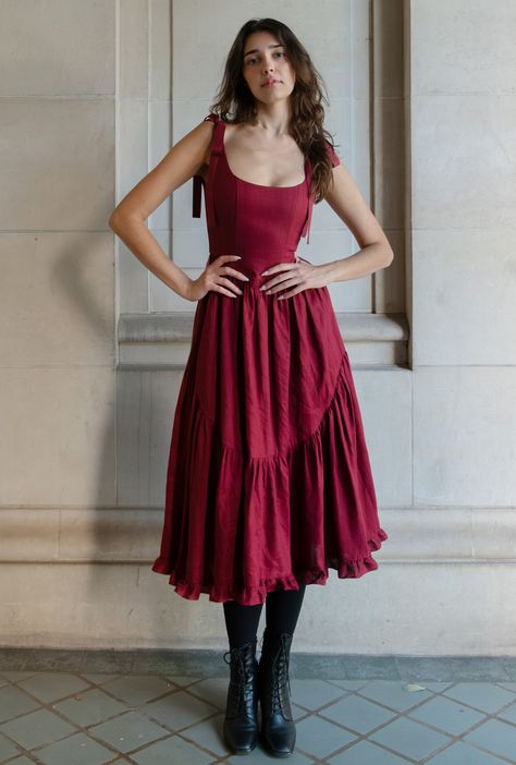 ready to ship xx a truly special dress. with rich ribbon tie straps, a corset bodice, and sweeping ruffle hem the mirabelle dress is dramatic, romantic beauty at its best and one of our most popular styles. updated in a beautiful, show stopping burgundy red and made in a lightweight linen with a sateen finish that gives the linen a subtle dressy luster. a showstopper of a dress made for holiday gatherings, celebrations, or romantic getaways. details: pockets, of course! lined bodice with boning, Princess Dresses Casual, Red Christmas Gown, Christmas Wedding Guest Dress, Corset Dress Aesthetic, Dress For Rectangle Body Shape, Bookish Costumes, Red Dress With Corset, Graduation Dress Red, Big Red Dress