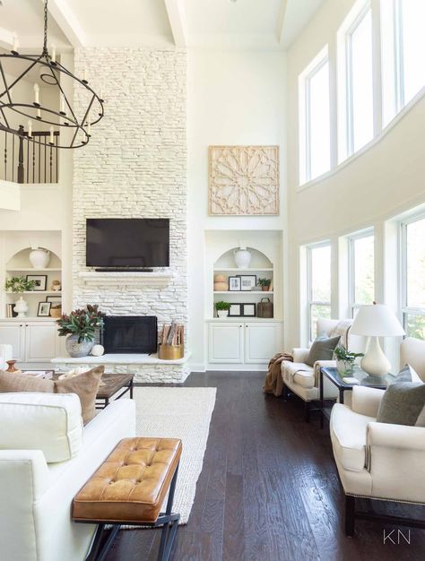 White Living Room Design with Statement Two Story Painted Stone Fireplace White Living Room Fireplace Ideas, White Stone Fireplace Living Room, White High Ceiling Living Room, Black Window Living Room, 2 Story Living Room Wall Decor Ideas, Tall Stone Fireplace Decor, White Tall Fireplace, Two Story Great Room Wall Decor Ideas, 2 Story Family Room Fireplace