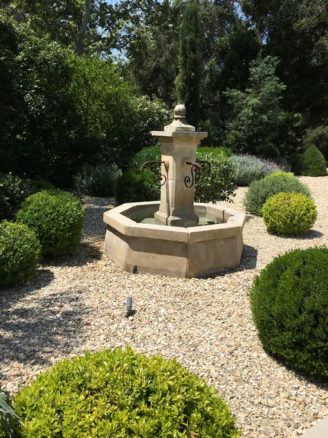 Our French Limestone fountains create the ideal centerpiece for your garden's design. This one shines in pea gravel and shrubs. Gravel Garden With Fountain, French Water Feature, Limestone Fountain Water Features, European Backyard, Garden Corner Ideas, French Fountains, Courtyard Fountain, Limestone Fountain, Landscaping Garden Design