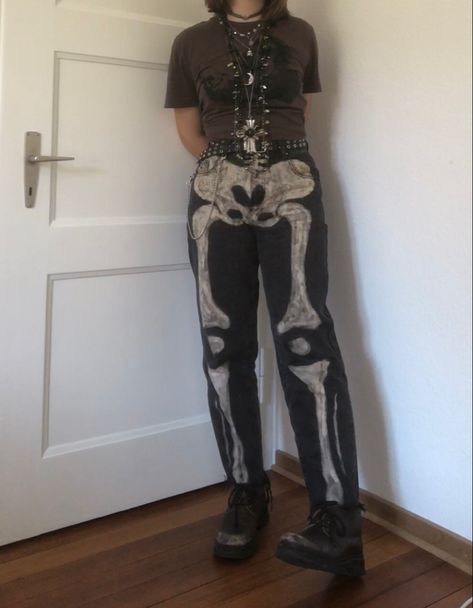 A mid-sized person/girl wearing a brown cropped shirt with a black ape on it and black jeans with bleached skeleton bones on them and a black leather belt, dark brown oxford shoes and multiple crystal rings and bracelets. 		The person is also wearing multiple silver necklaces. Bleach Shirt Art Aesthetic, Skeleton Jeans Diy, Skeleton Bleached Jeans, Skeleton Aesthetic Outfit, Pants Ideas Diy, Tech Core Outfits, Skeleton Inspired Outfit, Bleaching Ideas Clothes, Jeans Bleach Ideas