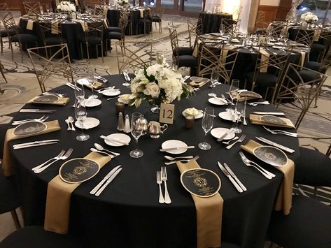 Awards Dinner Centerpieces, Black And Gold Round Table Setting, Black Gold Tablescape, Black And Gold Round Table Decorations, Black And Gold Gala Dinner Decor, Black And Gold Engagement Party Decor, Black And Gold Wedding Reception Decor, Black And Gold Casino Theme Party, Black White And Gold Table Decorations