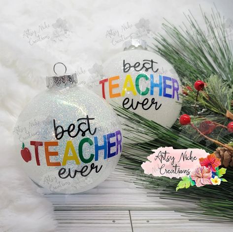 Spread cheer this holiday season by gifting your favorite teacher the Best Teacher Ever Christmas Ornament! Crafted with great attention to detail, this ornament celebrates the amazing efforts of teachers -- making a lasting impression on those who give and receive. Show your appreciation and make a statement with this special gift! 3" Glass Ornament Permanent vinyl lettering Comes with a white gift box This beautiful ornament uses 8 or or 9 colors for the vinyl on the outside, depending on opti Christmas Fillable Ornaments, Christmas Gifts For Coworkers Diy Ornaments, Glitter Christmas Ornaments With Vinyl, Christmas Teacher Gifts Cricut, Disk Ornament Ideas, Christmas Ornament Vinyl, Christmas Diy Gifts To Sell, Christmas Cricut Ornaments Diy, Personalized Glitter Ornaments