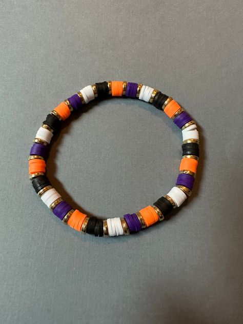 Orange, purple, black, and white clay bead bracelet with gold metal spacer beads.  Bracelet made with elastic string. Length is approx 7 inches unstretched.  Need a different size? Message me for custom options! Clay Needs Bracelets, Fall Loom Bracelet, Halloween Braclets Idea, Halloween Jewelry Diy Bracelets, Preppy Halloween Clay Bead Bracelets, Clay Beads Ideas Halloween, Halloween Clay Bead Ideas, Halloween Beaded Bracelet Ideas, Bracelet Ideas For Halloween