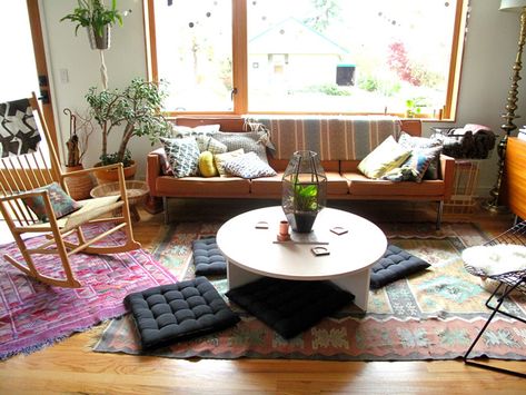 Casual and colorful living room, layered rugs, love the cushions around a low round coffee table Low Seating Living Room, Japanese Floor Seating, Floor Cushion Couch, Floor Cushions Living Room, Colorful Living Room, Dining Roo, Floor Sitting, Colourful Living Room, Layered Rugs