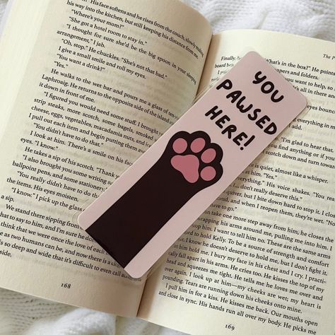 Happy #nationalbookloversday ! I’m so happy that I’m releasing my bookmarks on this day!!! Here’s one of my themes , I also have this available in doggy paws as well! These are completely handmade , hand drawn , and made with love! They’re laminated for extra protection as well 🩷 Share this with someone who loves cats!!! . . . #bookmarkshop #bookmarkart #catloverclub #bookishgirl #bookishart #bookloversofinstagram #bookstagram