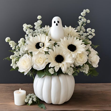 White Pumpkin Flower Arrangement with Ghost Accent Give the gift of everlasting silk flowers this fall with our enchanting ghostly fun flower arrangement in a charming pumpkin, complete with a playful ghost accent. This spooky yet sophisticated arrangement features a mix of delicate white blooms, such as roses, lilies, and mums, artfully arranged inside a classic white pumpkin. The subtle ghost detail adds a whimsical touch, making this the perfect centerpiece for Halloween gatherings or autumn celebrations. Whether you're gifting a loved one or adding a festive flair to your home or office for a party, this arrangement brings whimsy and a touch of spooky charm to any gift giving flower arrangement for a birthday or get well flower giving or just because. it’s the perfect choice for those Halloween Silk Flower Arrangements, White Fall Floral Arrangements, Ghost Floral Arrangement, White Fall Centerpieces For Table, Halloween Floral Design, Pumpkin Flower Vase, Fall Pumpkin Flower Arrangements, Flowers In Pumpkins Floral Arrangements, Halloween Arrangements Ideas