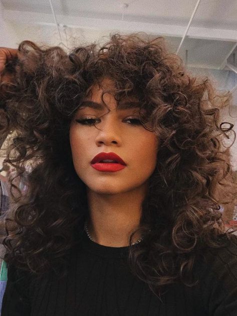 This Low-Maintenance Haircut Is Set to Be Huge in 2021 Zendaya Makeup, Zendaya Hair, 70s Hair, Curly Bangs, Red Lip Makeup, Classic Hairstyles, Curly Hair With Bangs, Red Lipstick, Long Curly Hair