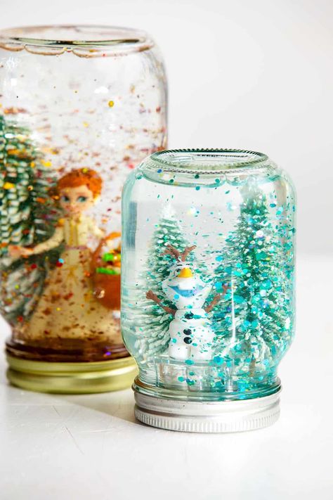 Making your own snow globe is easier than you think! Follow these simple instructions to create your own, DIY Snow Globe with the kids. #WelcometoNanas #DIYSnowGlobe #EasyCraftsforKids #SnowGlobewithGlue Galaxy Snow Globe Diy, Mason Jar Snow Globes Diy, Lighted Snow Globes Diy, Diy Snow Globe Videos, Diy Winter Snow Globe, Kid Snow Globe Craft, Snow Globe Activity, Lego Snow Globe, Homemade Christmas Snow Globes