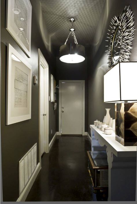 There’s no rule that says you have to paint a narrow hallway a light color. In fact, a dark hue adds drama and definition — especially when contrasted with white. To achieve the look pictured here, we suggest Black Oak KMA89 and Acoustic White 46. Hallway Paint Colors, Black Hallway, Grey Hallway, Hallway Paint, Design Hall, Small Hallway Ideas, Hallway Designs, Hallway Design, Long Hallway