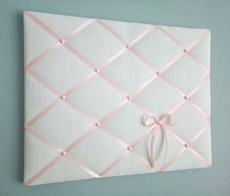 This delicate memo board in white linen fabric is accented with light pink satin ribbon and faux pearl details. Use it to display your photos, notes and cards, or just on its own as one of a kind soft wall hanging. Sizes: 20in wide x 16in tall (pictured) 24in wide x 18in tall 24in wide x 20in tall **Other sizes available, please contact me for details.** My memo boards and fabric pictures are carefully handcrafted using high quality materials, with generous batting. All my boards are light weigh Fabric Photo Board, Cork Board Covered In Fabric, Pink Walls Bedroom Ideas, Memo Board Diy, Pin Board Ideas, Pink Linen Fabric, Fabric Memo Boards, Pink Dorm, White Linen Fabric