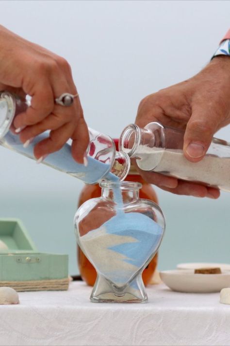 Unity Sand Jar Ceremony Wedding Ritual | Sarasota Florida Beach Wedding Service | Beach Wedding Planners | Florida Sun Weddings | Wedding Couple Pours Different Colored Sand into a Heart Shaped Jar | Wedding Memento | Beach Wedding Ideas Inspiration | Get Married on the Beach | Beach Wedding Ceremony Ideas | Blessign Shell Wedding Ritual Magenta Wedding Decorations, Sand Jar, Ariel Wedding, Magenta Wedding, Sand Ceremony Wedding, Wedding Ceremony Unity, Unity Sand Ceremony, Unity Sand, Wedding Ceremony Ideas