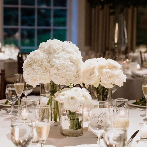 Cluster Flower Arrangements, Modern White Centerpiece Wedding, Low And Lush Centerpieces, Large Cylinder Vase Decor Wedding, Rose Bouquet Centerpieces, Wedding Flowers In Vases, White Hydrangea Table Arrangements, White Ranunculus Centerpiece, White Flower Wedding Reception