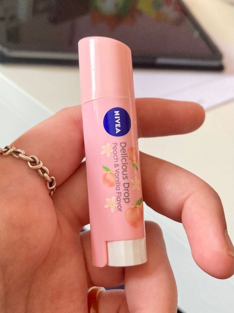 It's a delicious drop nivea lip balm. it's a pale peachy pink colour and has little vanilla flowers and peaches on it. It's being held in a white hand with a silver ring on it. Peach Perfume Aesthetic, Nivea Peach Lip Balm, Chapstick Aesthetic, Lip Balm Aesthetic, Aesthetic Peach, Nivea Lip Balm, Peach Lip Balm, Peach Jelly, Peach Lipstick