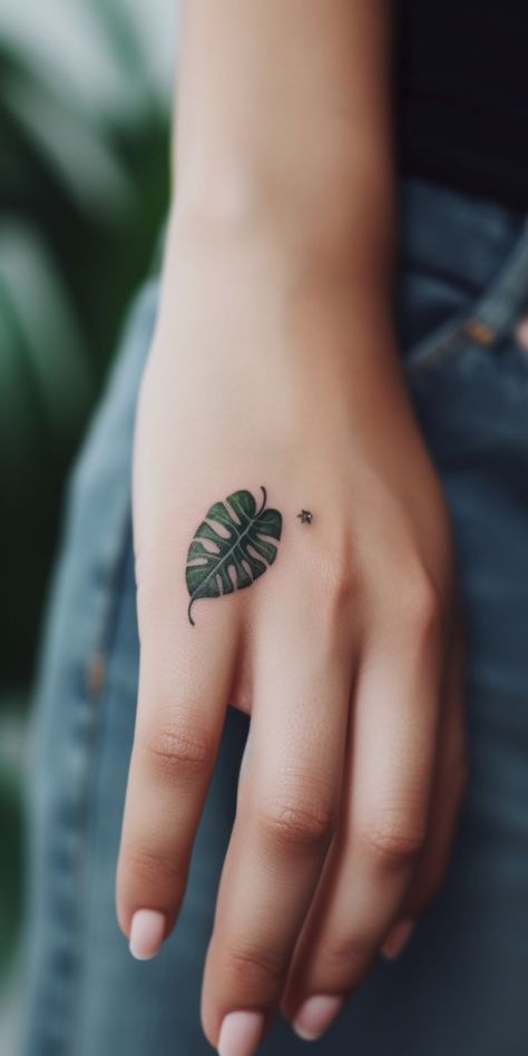 A fascinating monstera leaf handball tattoo, highlighting an expertly designed pattern with refined shading, flowing lines, and an elegant design, encapsulating the essence of serenity, growth, and nature's beauty. This elegant tattoo enables a stylish yet meaningful expression of personal emotions, connection to nature, and individual fashion on your handball. Handball Tattoo, Tattoos For Lovers, Plant Tattoo, Latest Tattoos, Face Tattoos, Tattoo Trends, Nature Tattoos, Monstera Leaf, Temporary Tattoo