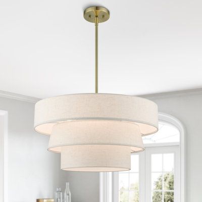 The pendant chandelier is both modern and versatile. The hand-crafted off-white colored fabric hardback shade is set off by the silky white fabric on the inside setting a pleasant mood. The triple drum shade adds character to this handsomely styled pendant. Perfect fit for the living room, dining room, kitchen, and bedroom. Base Finish: Antique Brass, Shade Color: Beige | Latitude Run® Samire 4 - Light Dimmable Drum Chandelier Textile / Metal in Yellow / Brown | Wayfair Fabric Drum Chandelier, Modern Organic Light Fixtures, Drum Chandelier Dining Room, Drum Shade Chandelier, Bedroom Chandelier, Chandelier White, Bedroom Light Fixtures, Bubble Chandelier, I Love Lamp