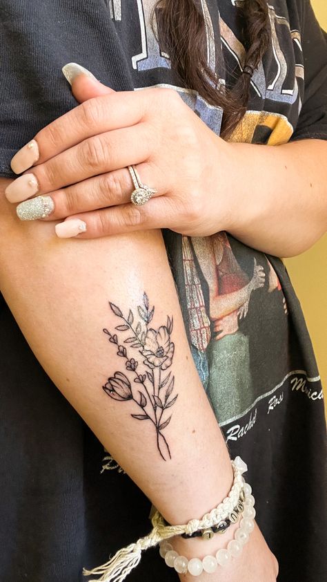 Black and gray simple wildflower tattoo on forearm Flower And Greenery Tattoo, You Belong Among The Wildflowers Tattoo, Wildflower Tattoo Forearm, Greenery Tattoo Sleeve, Greenery Tattoo, Flower Bookey, Front Thigh Tattoos, Floral Arm Tattoo, Floral Back Tattoos