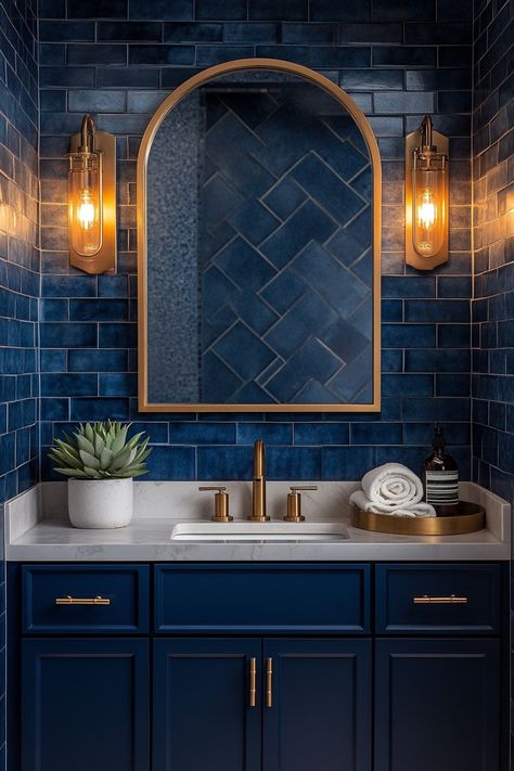 Transform your bathroom with these striking wall art ideas! Enhance your decor with rich blue tiles and warm lighting for a luxurious touch. Discover more chic design tips to elevate your space today! #BathroomDecor #InteriorDesign #WallArtIdeas Bathroom Dark Blue Walls, Blue Bathroom With Gold Fixtures, Blue And Gold Bathroom Vanity, Dark Blue Toilet Room, Guest Bathroom Ideas Blue, Navy Blue Tile Shower Ideas, Blue Gold Bathroom Ideas, Navy And Gold Bathroom Ideas, Dark Blue And Gold Bathroom