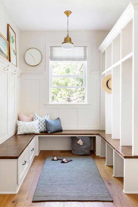 Mudroom features a brown wooden u-shaped built-in bench with white drawers and black pulls, white open lockers, and a gray rug, illuminated by a brass and white lantern. Cottage Laundry Room, Bria Hammel Interiors, Laundry Room Paint Color, Bria Hammel, Mudroom Cabinets, Mudroom Lockers, Holly House, Mudroom Design, Bench Designs