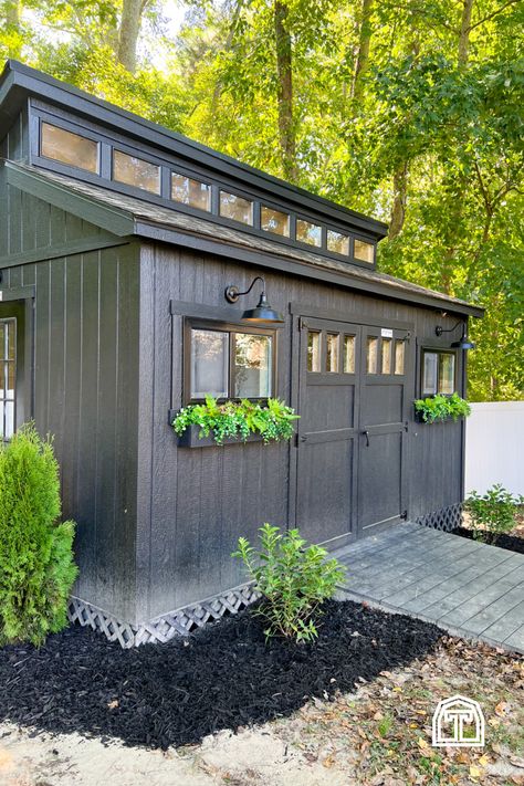 We love this modern shed workshop! There's charm inside and out of Cass' woodworking and DIY workshop shop, and it's filled with so many personal customizations and DIY design ideas. With an all-black paint scheme and bright exterior lighting, these beautiful shed design ideas make for a perfect backyard workshop shed. Add the space you need for DIY projects and infuse your style into your new backyard shed with inspiration from this modern shed workshop, filled with storage ideas and designs. Small Workshop Shed Ideas, Around The Shed Landscaping, Shrubs Around Shed, Shed With Planter Boxes, Black Outdoor Shed, Shed Addition To House, Outdoor Buildings Storage Sheds, Sea Can Shed, Attached Shed To House