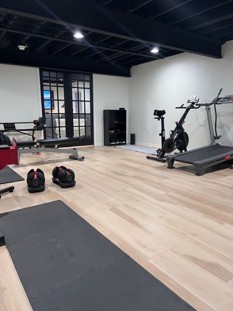 Basement Gym Black Ceiling, Basement Gym And Family Room Floor, Home Gym Black Ceiling, Basement Remodel Black Ceiling, Black And White Home Gym, Basement Gym Remodel, Basement Gym Lighting, Unfinished Basement Workout Room, Basement With Black Ceiling