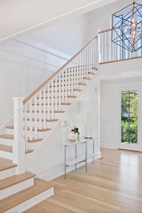 Stunning light wood staircase with wood and white railings. Custom wall paneling. Black chandelier. Light wood floors. Slim frame windows. Staircase Design White And Wood, Double Landing Staircase, Light Wood Banister, Cottage Core Staircase, All White Stair Railing, White Wood Staircase, White Stair Railing Ideas, White And Wood Stairs, White Wood Stairs