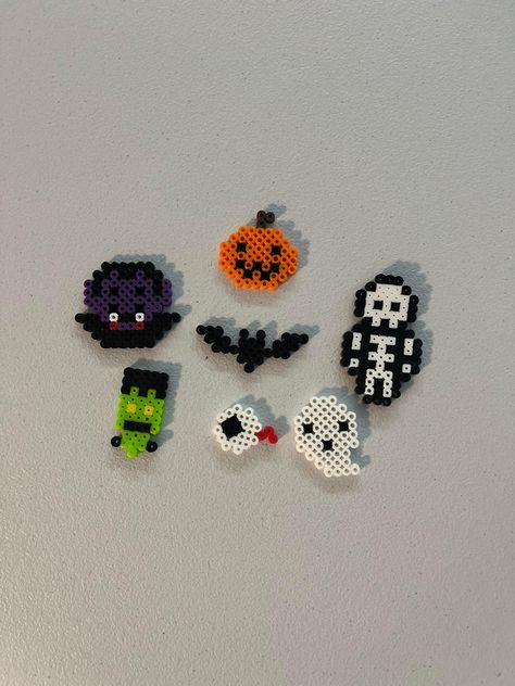 These are keychain sized Halloween designs made of Perler beads. Melt Beads Patterns Halloween, Halloween Perler Beads 3d, Melty Bead Halloween, What To Do With Perler Bead Creations, Perler Bead Pants Chain, Halloween Perler Bead Patterns Pumpkins, Music Note Perler Beads, Mini Perler Bead Patterns Halloween, Iron Beads Halloween