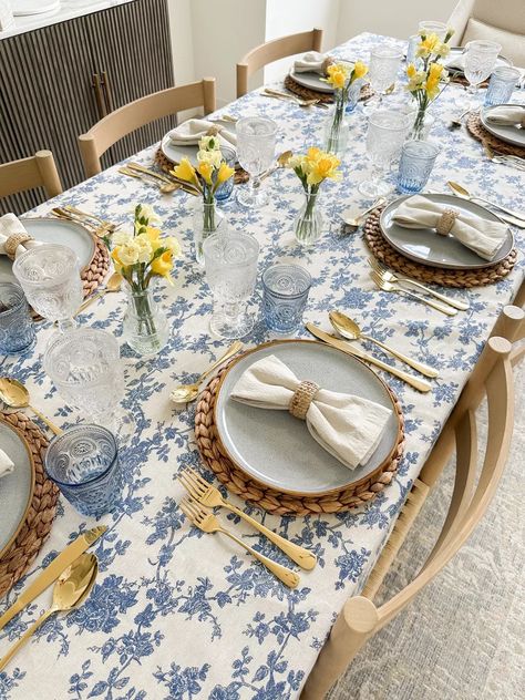 Elevate Your Spring Dining with a Stylish Tablescape! 🌼🍴 Create a stunning spring ambiance with a floral print tablecloth that's perfect for setting the scene. Accentuate with blue ceramic plates, linen napkins, rattan napkin rings, woven placemats, and gold flatware for a touch of sophistication. And for that nostalgic flair, add in vintage bud vases and goblets to complete the picture-perfect table decor. Click the link to shop! Blue Floral Tablecloth, Vintage Plates Table Setting, Rattan Placemats Table Settings, Woven Placemats Table Setting, Spring Table Scape, China Plates Wedding, Blue Tablescape, Floral Table Setting, Blue Table Settings