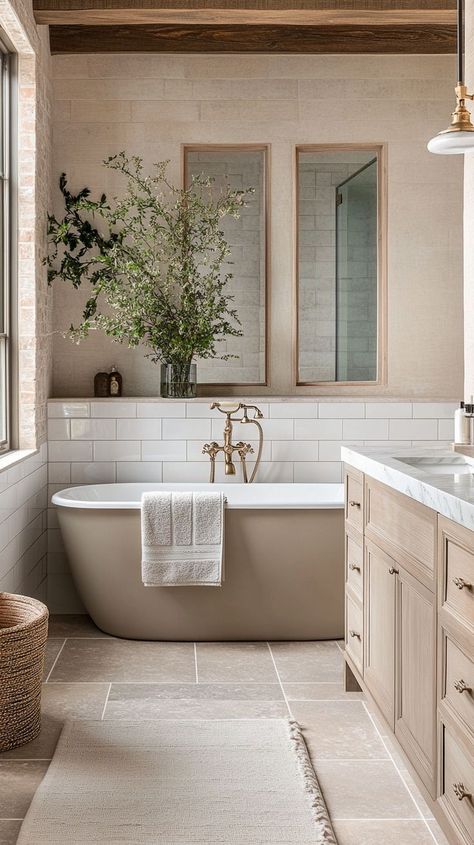 A beige coloured bath in a warm and welcoming bathroom with natural stone on the walls and flooring. Jenny Marrs Bathroom, Bathroom With Wood Beams, Light Wood Master Bath, Neutral Toned Bathroom, California Spanish Bathroom, Neutral Natural Bathroom, Non White Bathroom, Bathroom Country Modern, Bathroom Ideas Organic Modern